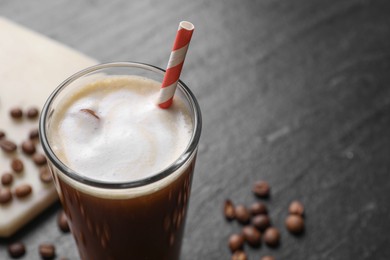 Photo of Refreshing iced coffee with milk in glass on dark gray table, closeup. Space for text