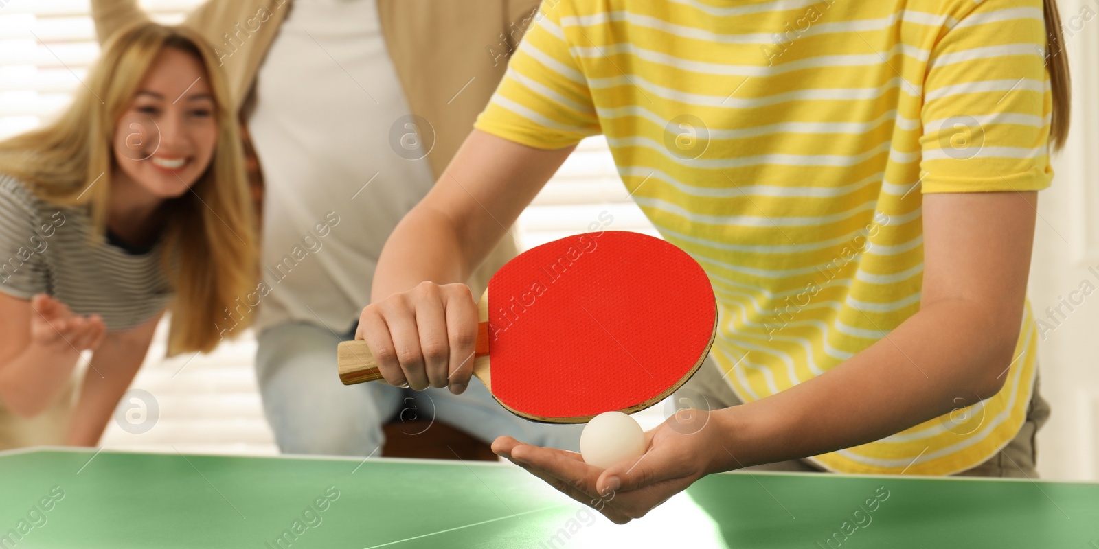 Image of Woman playing ping pong with friends indoors, closeup. Banner design