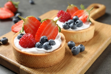 Photo of Delicious sweet pastries with berries on grey table, closeup