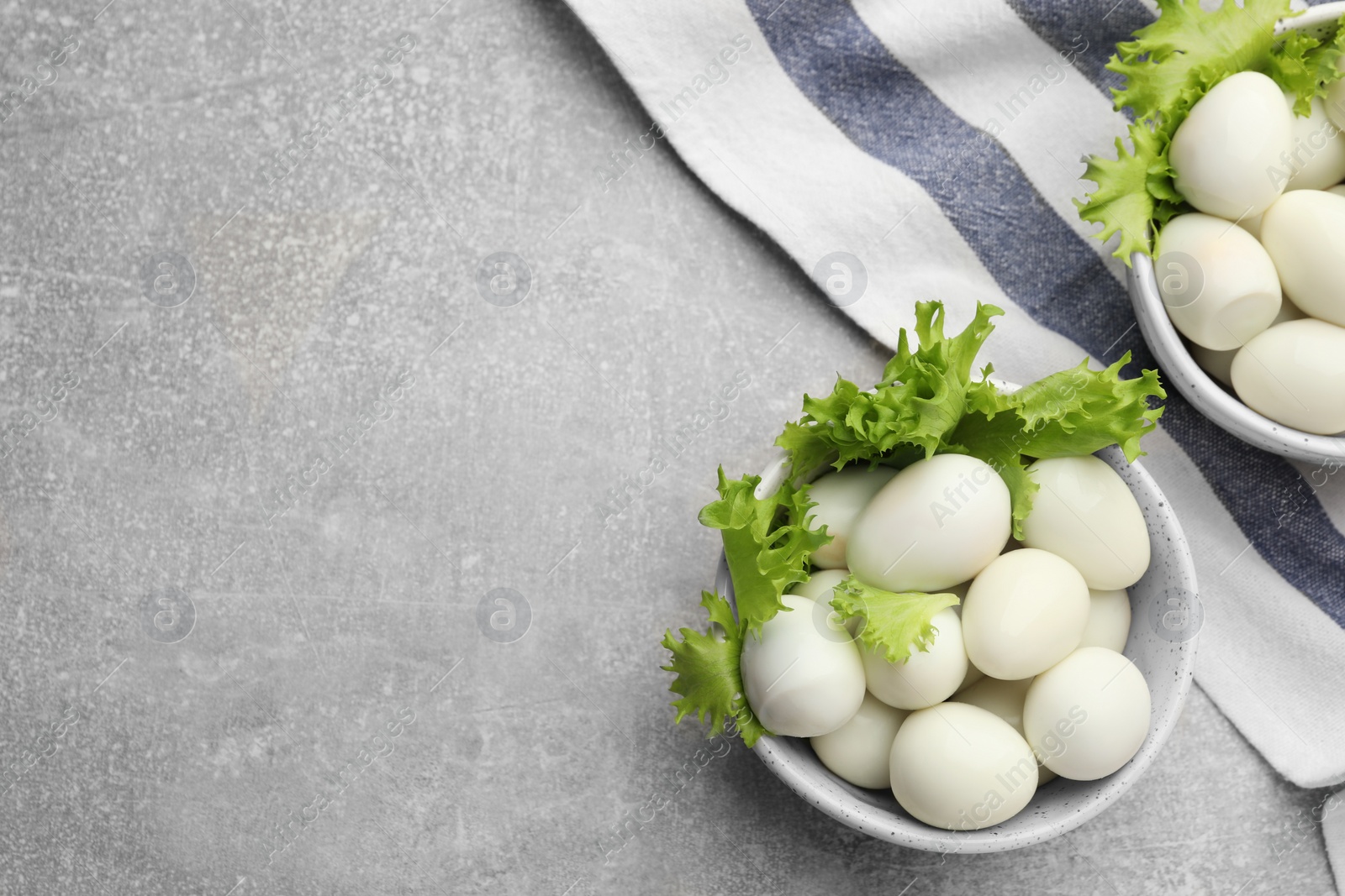 Photo of Peeled boiled quail eggs on grey table, flat lay. Space for text