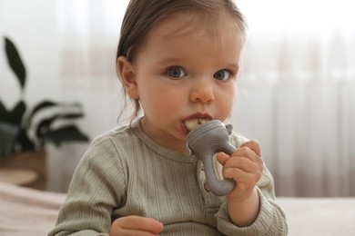 Photo of Cute baby girl with nibbler at home