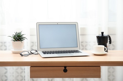 Photo of Cozy blogger workplace with laptop at home