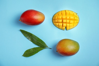 Photo of Flat lay composition with ripe mangoes and leaves on color background