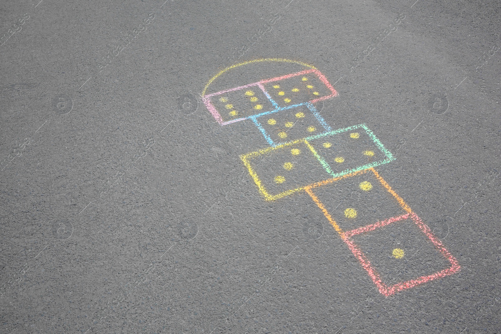 Photo of Hopscotch drawn with colorful chalk on asphalt outdoors. Space for text