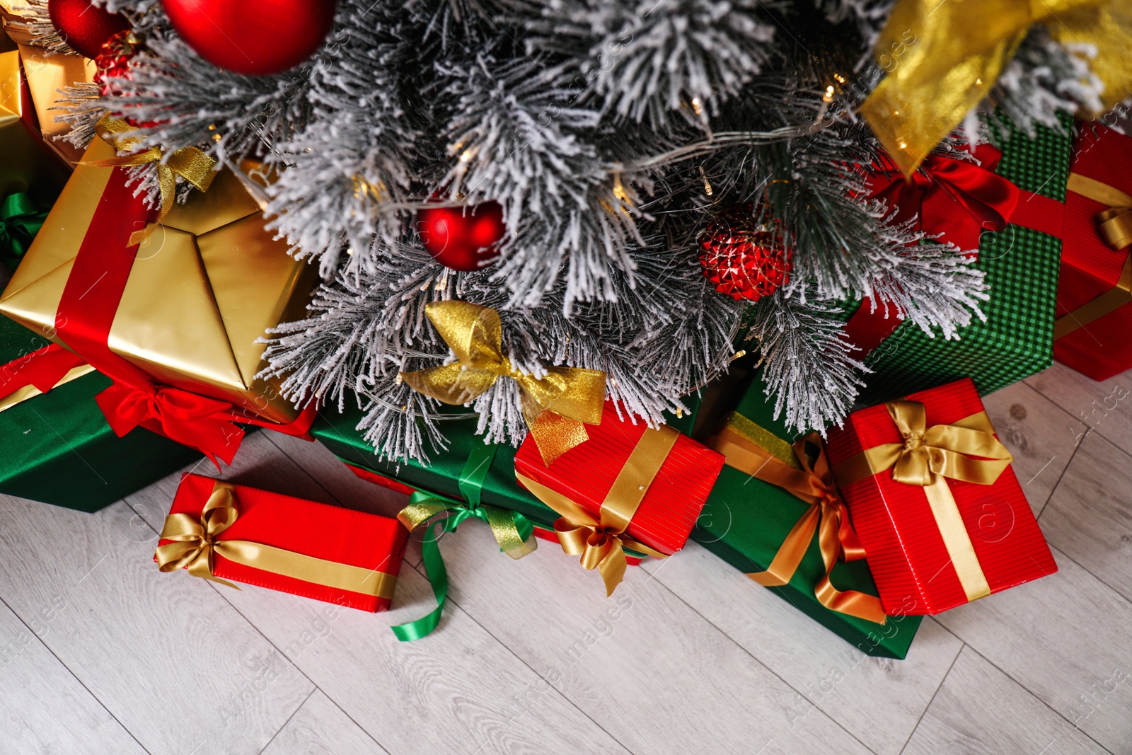 Photo of Decorated Christmas tree and gift boxes indoors, top view. Stylish interior element