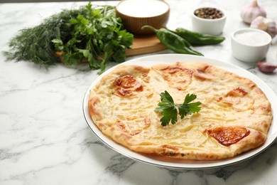 Photo of Delicious khachapuri with cheese on white marble table