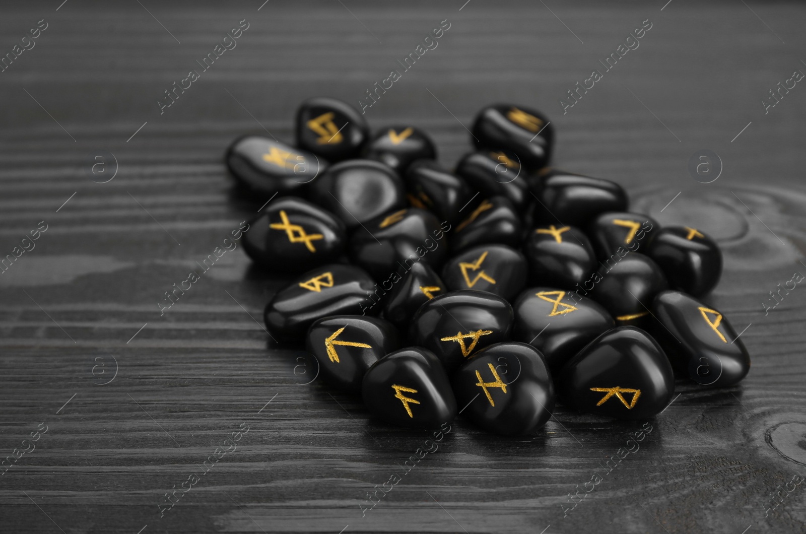 Photo of Pile of rune stones on black wooden table