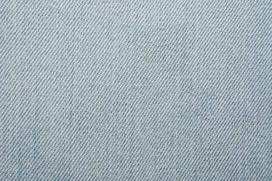 Texture of light blue jeans as background, closeup