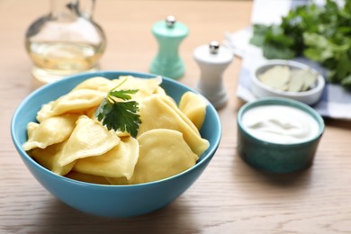 Photo of Tasty dumplings in bowl served on wooden table