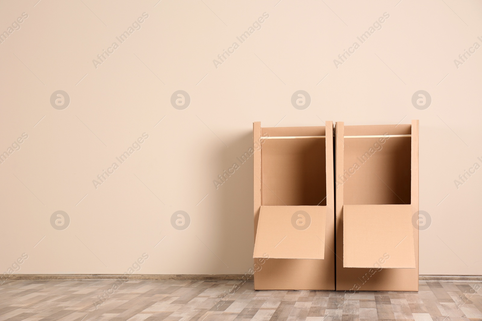 Photo of Empty wardrobe boxes against color wall indoors. Space for text