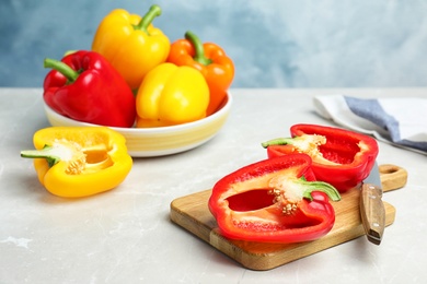 Cut and whole ripe bell peppers on marble table