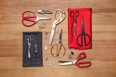 Flat lay composition with different sewing accessories on wooden background