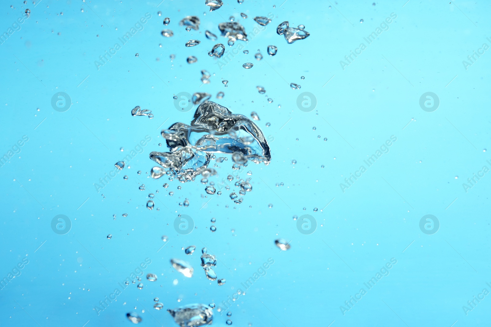 Photo of Air bubbles in water on light blue background