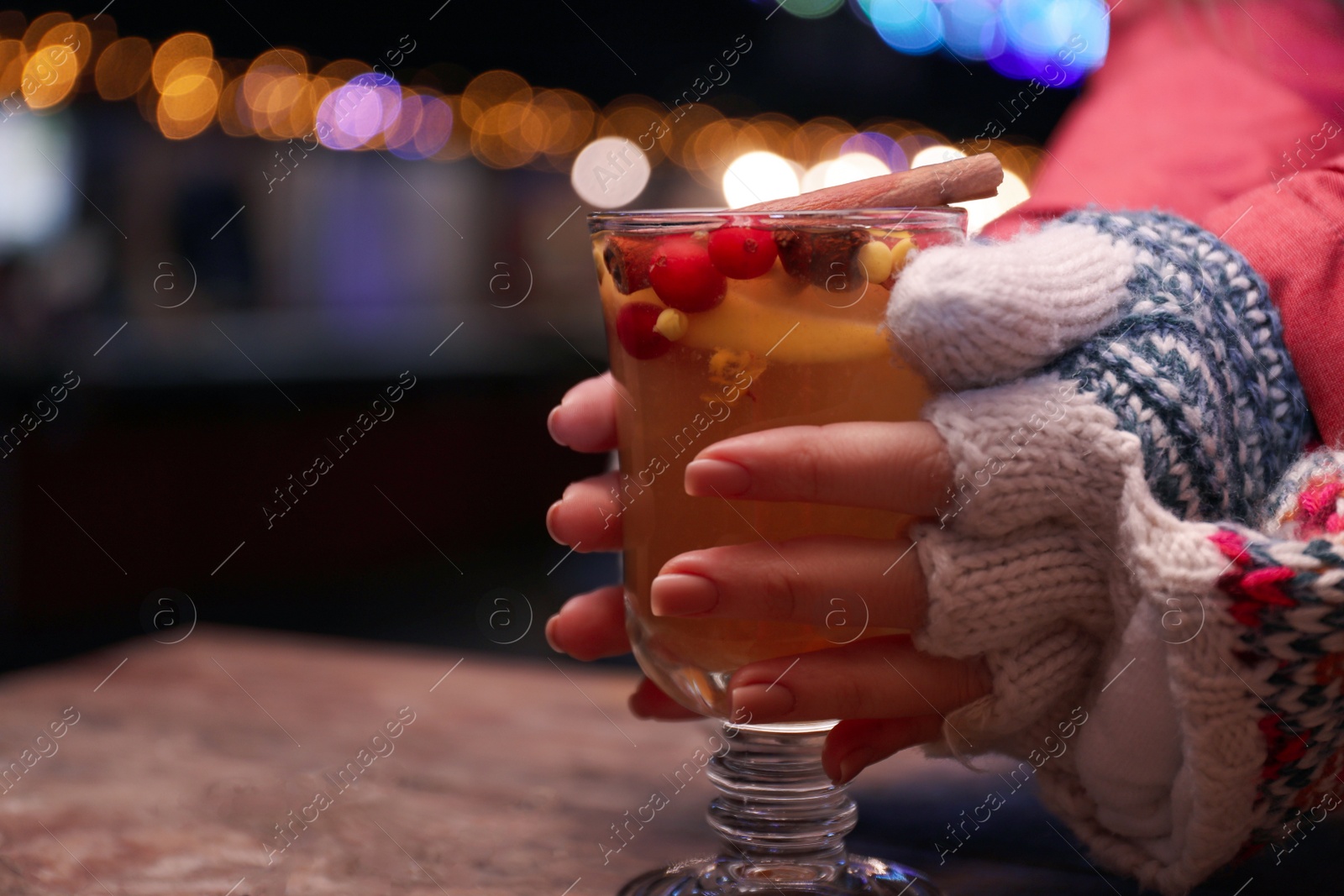 Photo of Woman with mulled wine at table, closeup