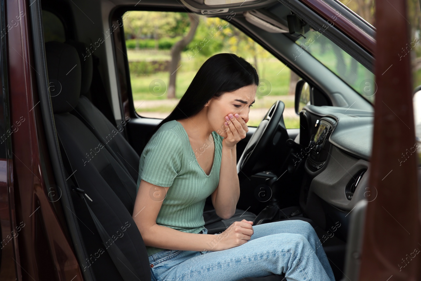 Photo of Young woman suffering from nausea in car