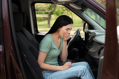 Photo of Young woman suffering from nausea in car