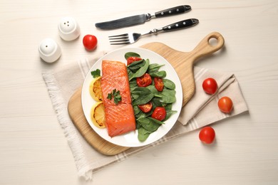 Photo of Tasty grilled salmon with basil, tomatoes and lemon on white wooden table, flat lay