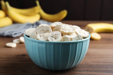 Photo of Freeze dried and fresh bananas on wooden table, closeup