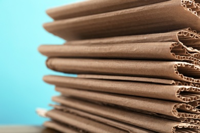 Stack of cardboard for recycling on color background, closeup