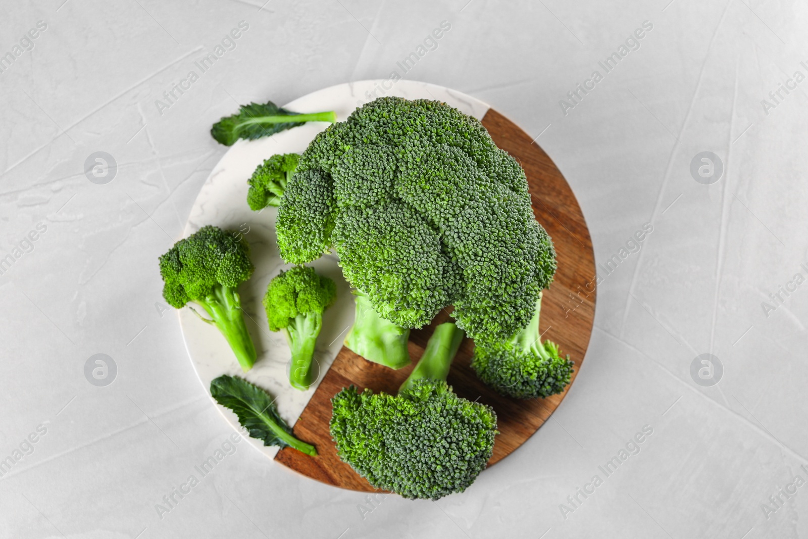 Photo of Fresh raw broccoli on white table, top view