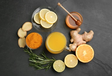 Photo of Flat lay composition with immunity boosting drink and ingredients on dark table