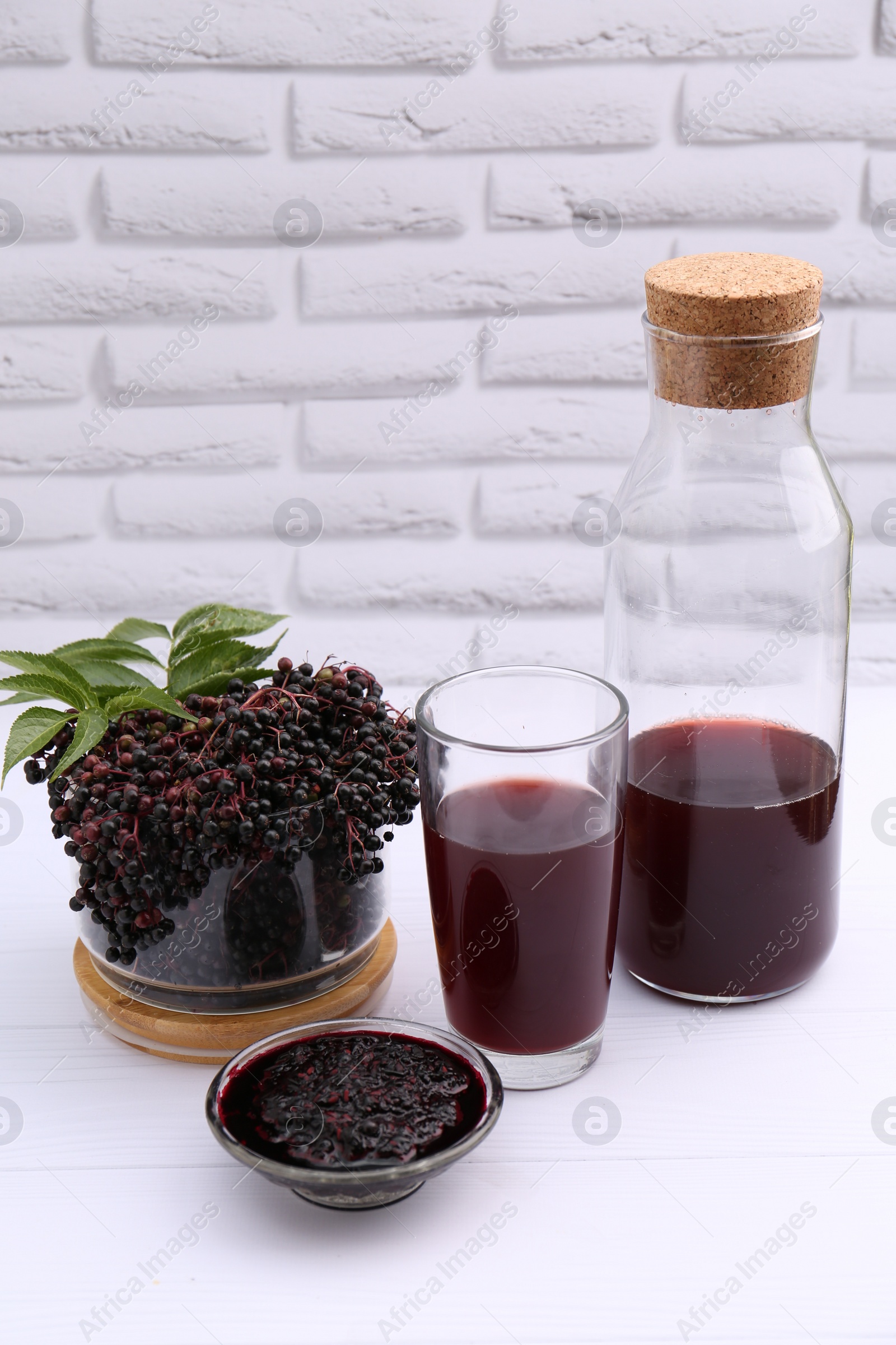 Photo of Elderberry drink and jam with Sambucus berries on white wooden table, space for text