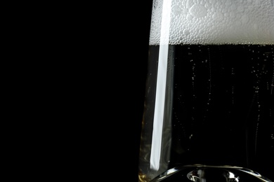 Photo of Glass of champagne on black background, closeup. Space for text