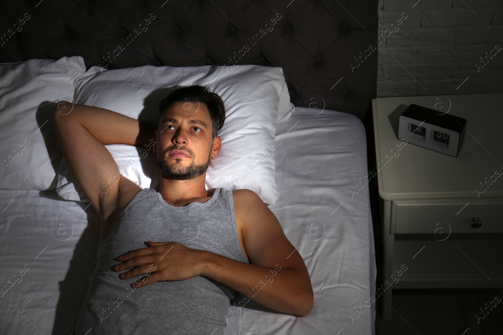 Photo of Man suffering from insomnia in bed at home