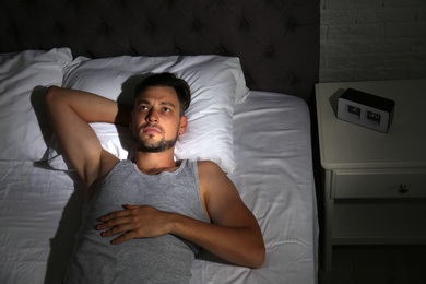 Photo of Man suffering from insomnia in bed at home