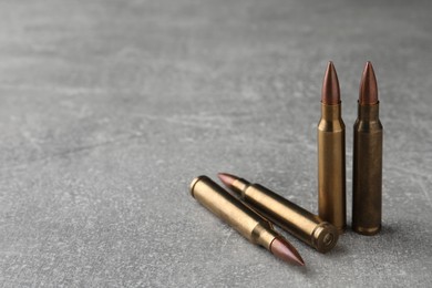 Photo of Bullets on light grey table, closeup. Space for text