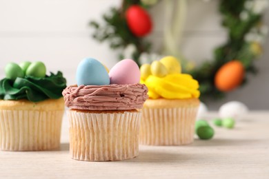 Tasty decorated Easter cupcakes on wooden table, closeup