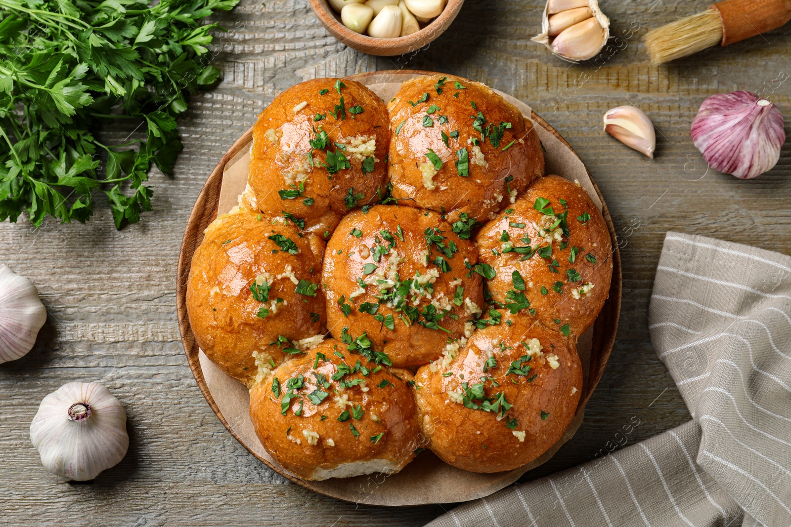 Photo of Traditional Ukrainian garlic bread (Pampushky) on wooden table, flat lay