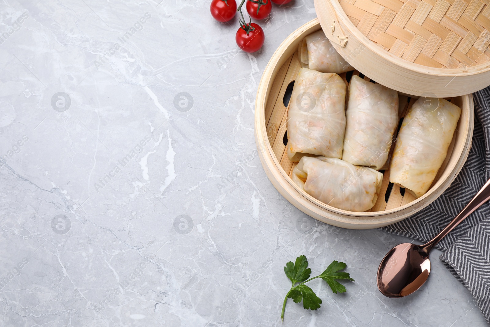 Photo of Delicious cabbage rolls served on grey marble table, flat lay. Space for text