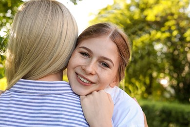 Happy daughter with her mother spending time together in park on sunny day