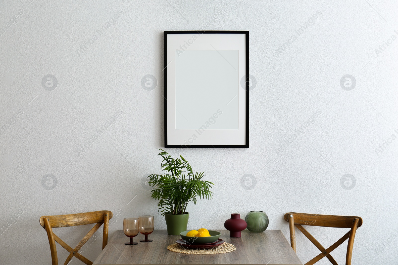 Photo of Room interior with dining table, wooden chairs and photo frame