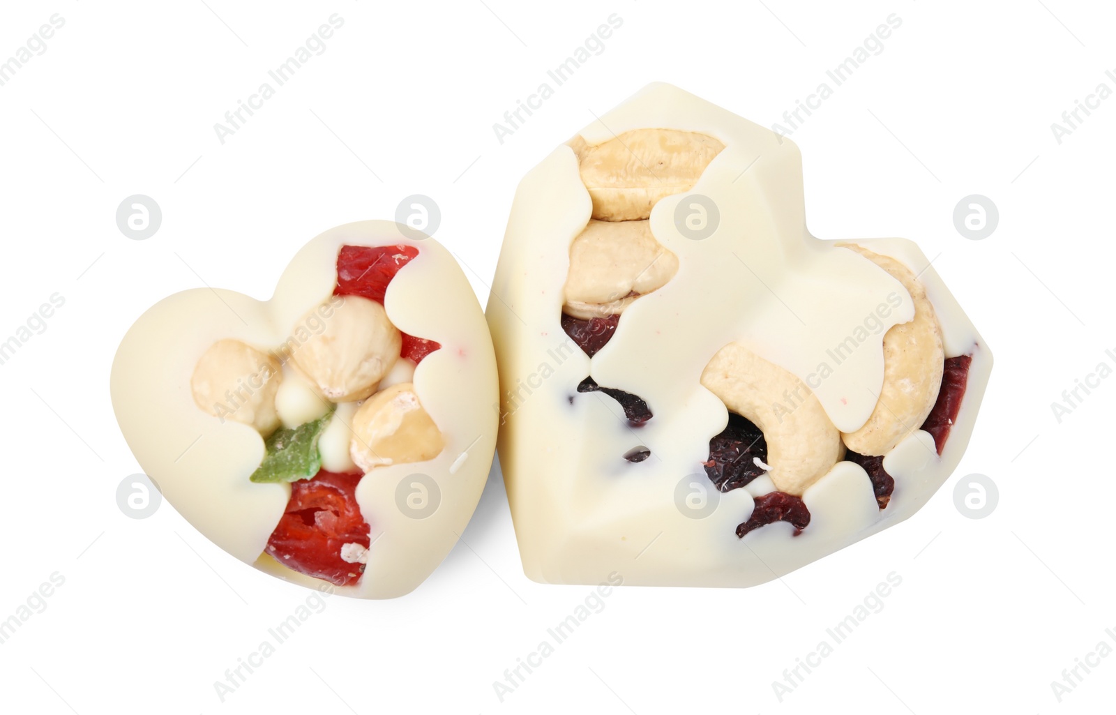 Photo of Tasty chocolate heart shaped candies with nuts on white background, top view