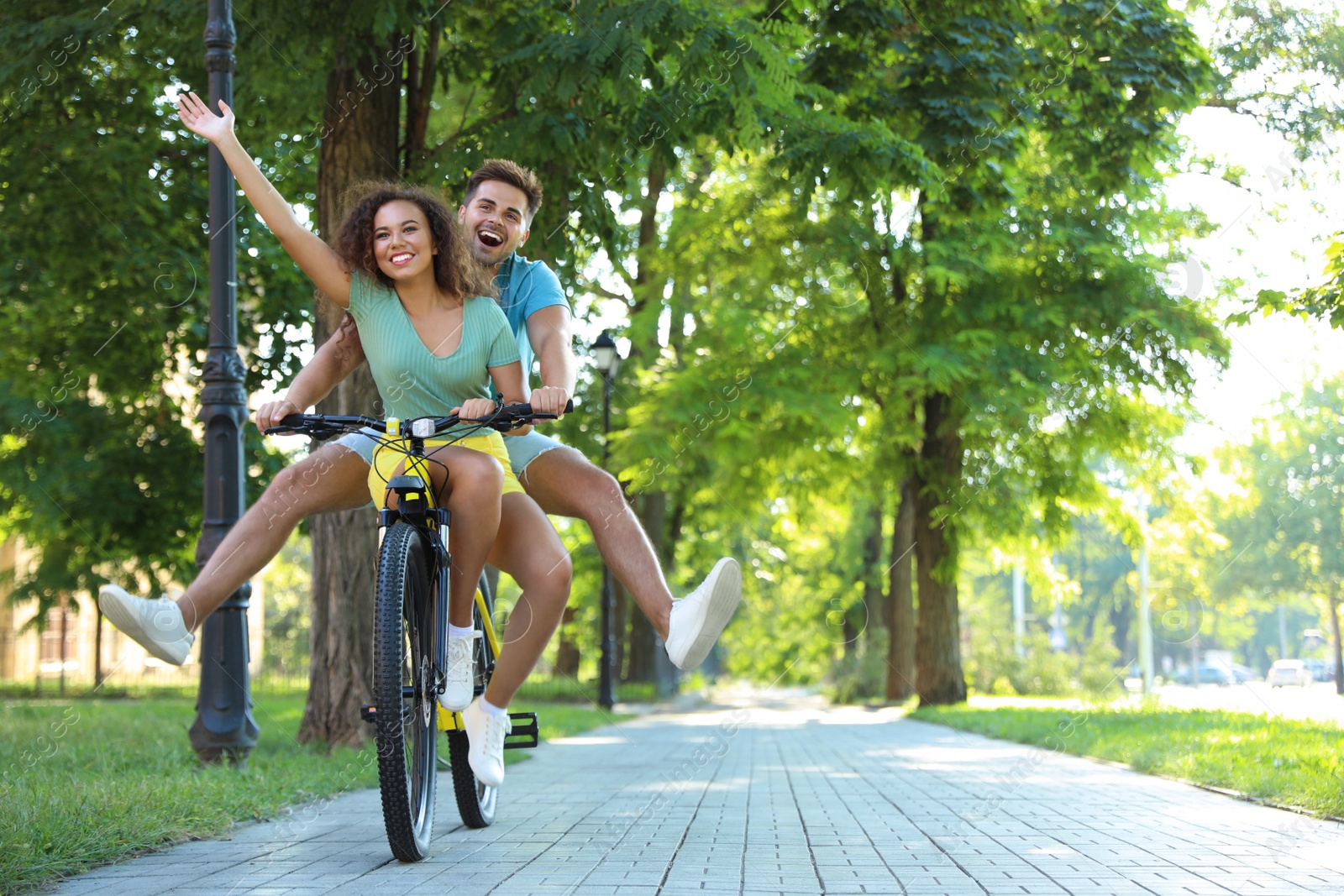 Photo of Happy young couple riding bicycle on city street