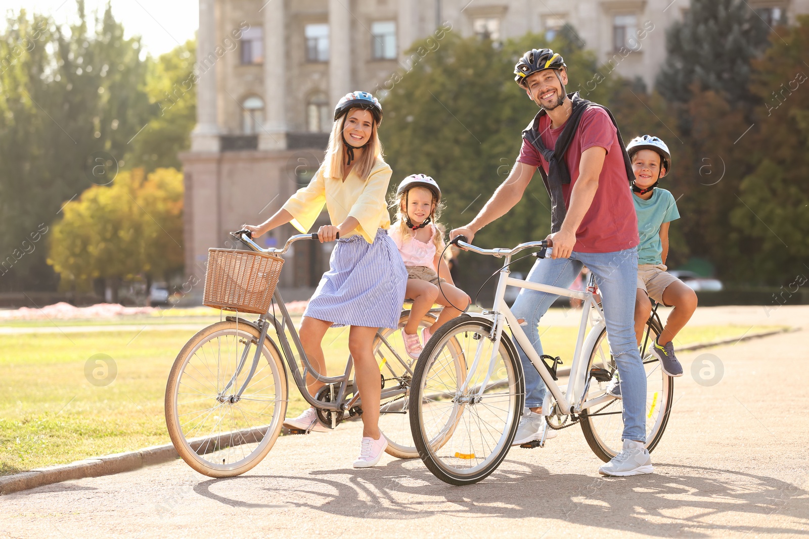 Photo of Happy family riding bicycles outdoors on summer day