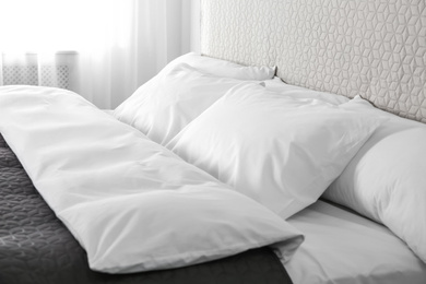 Photo of Bed with soft fluffy pillows at home