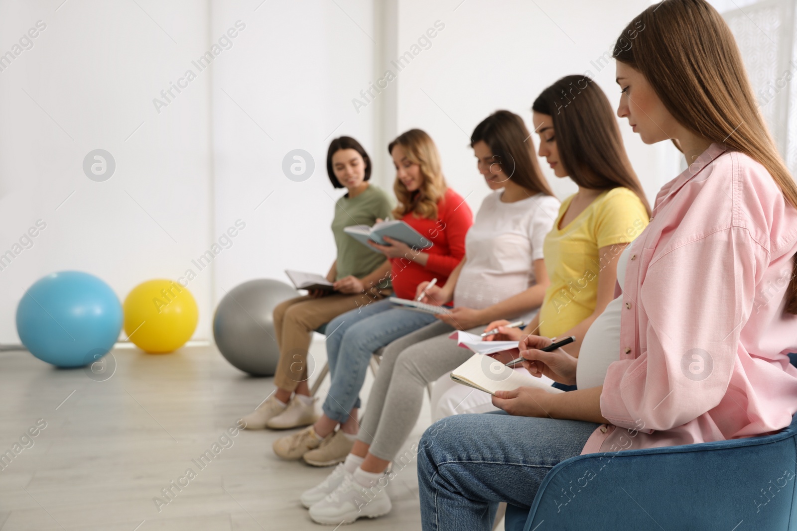 Photo of Group of pregnant women at courses for expectant mothers indoors