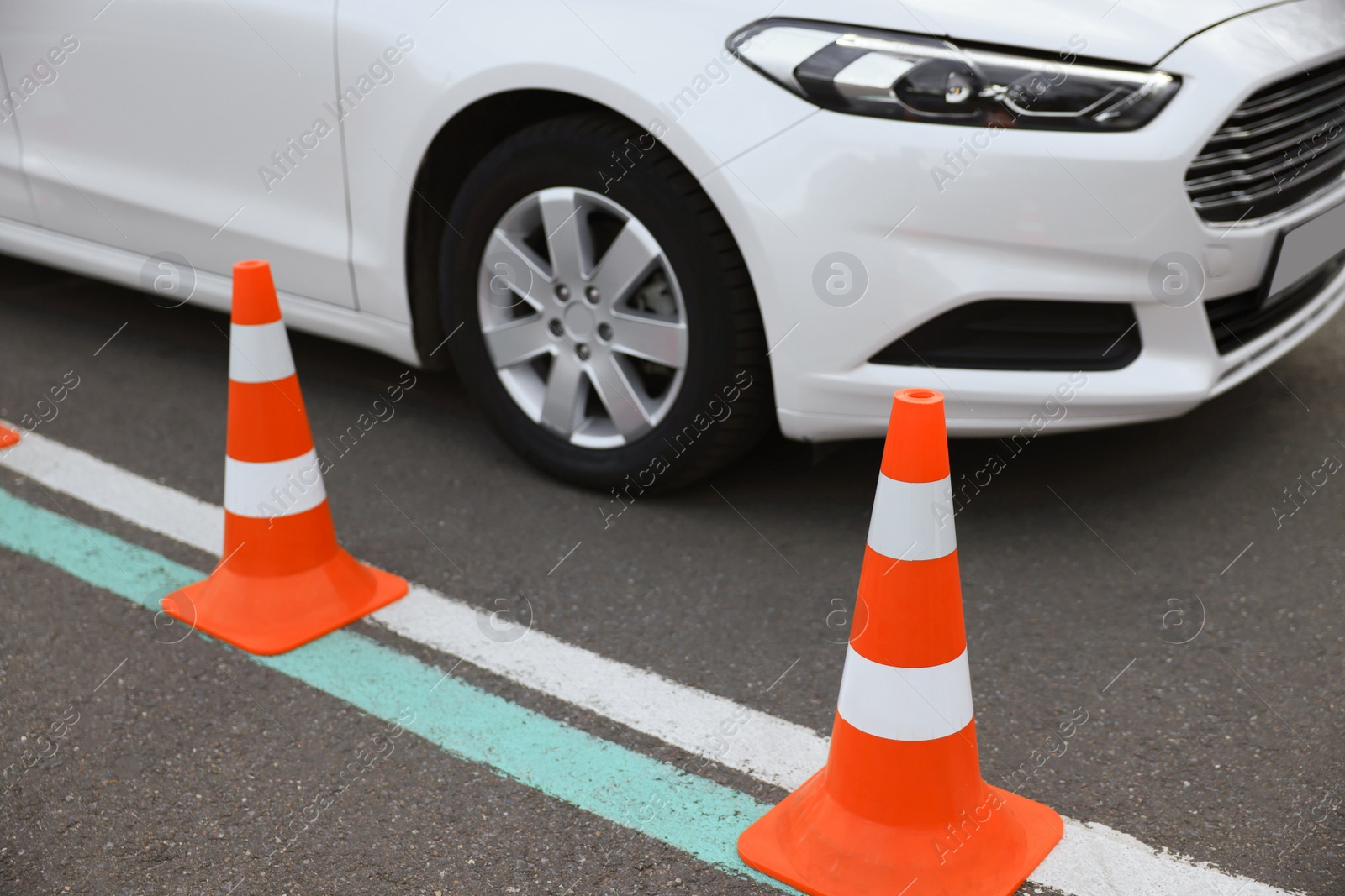 Photo of Modern car on test track with traffic cones, closeup. Driving school