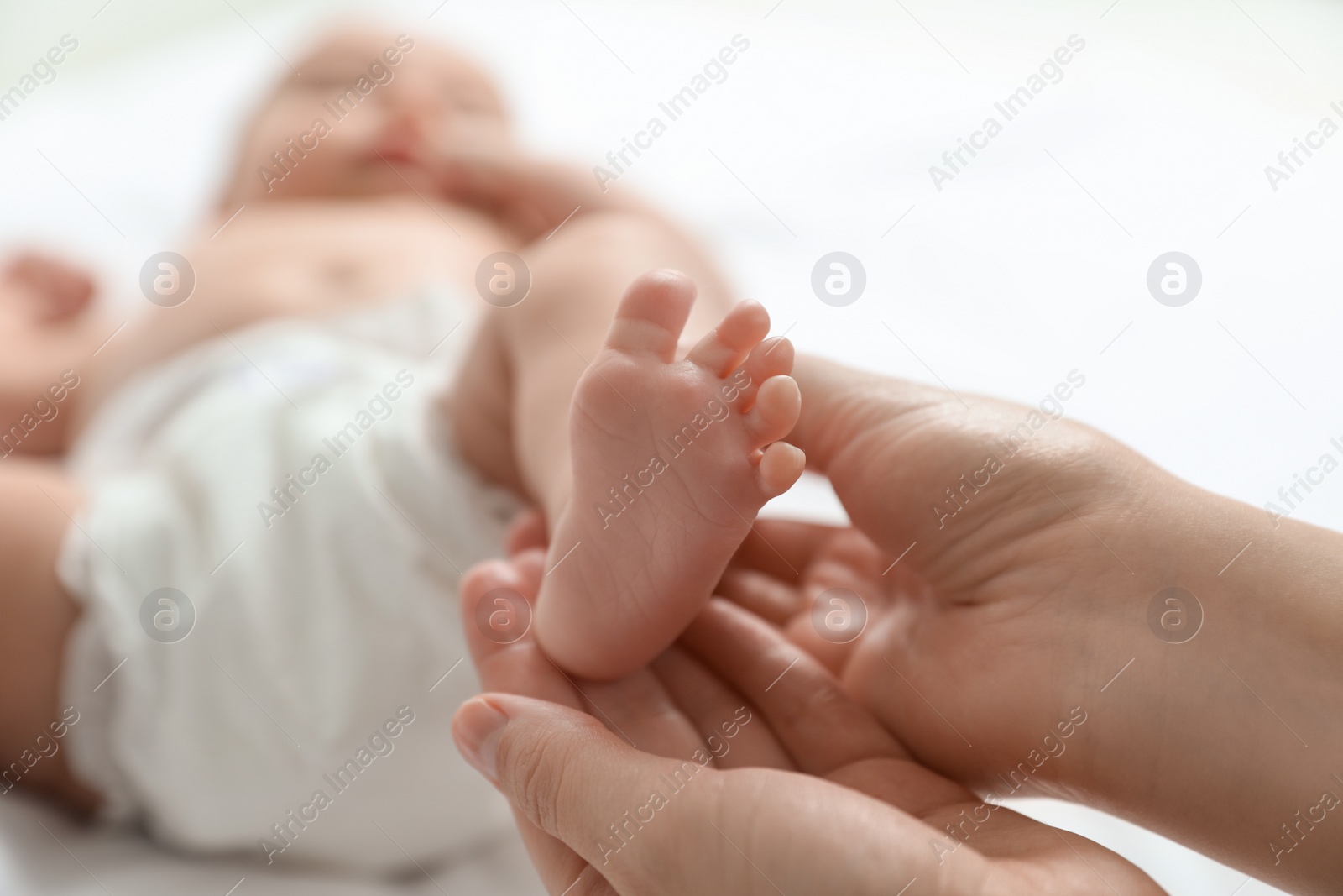 Photo of Mother massaging her cute baby with oil, closeup