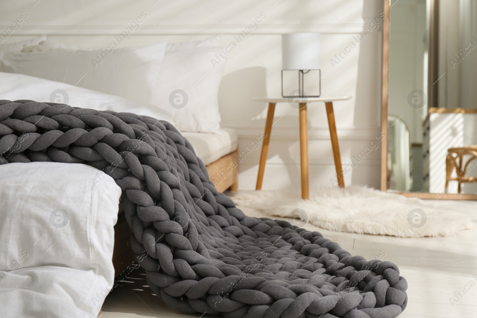 Photo of Soft chunky knit blanket on bed in room