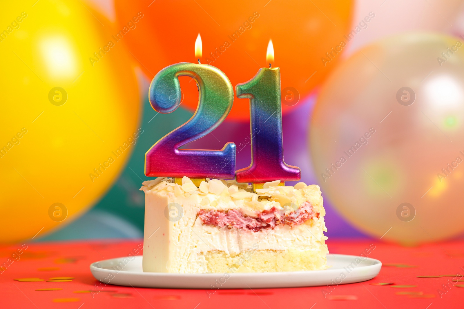 Photo of Coming of age party - 21st birthday. Delicious cake with number shaped candles on red table near balloons