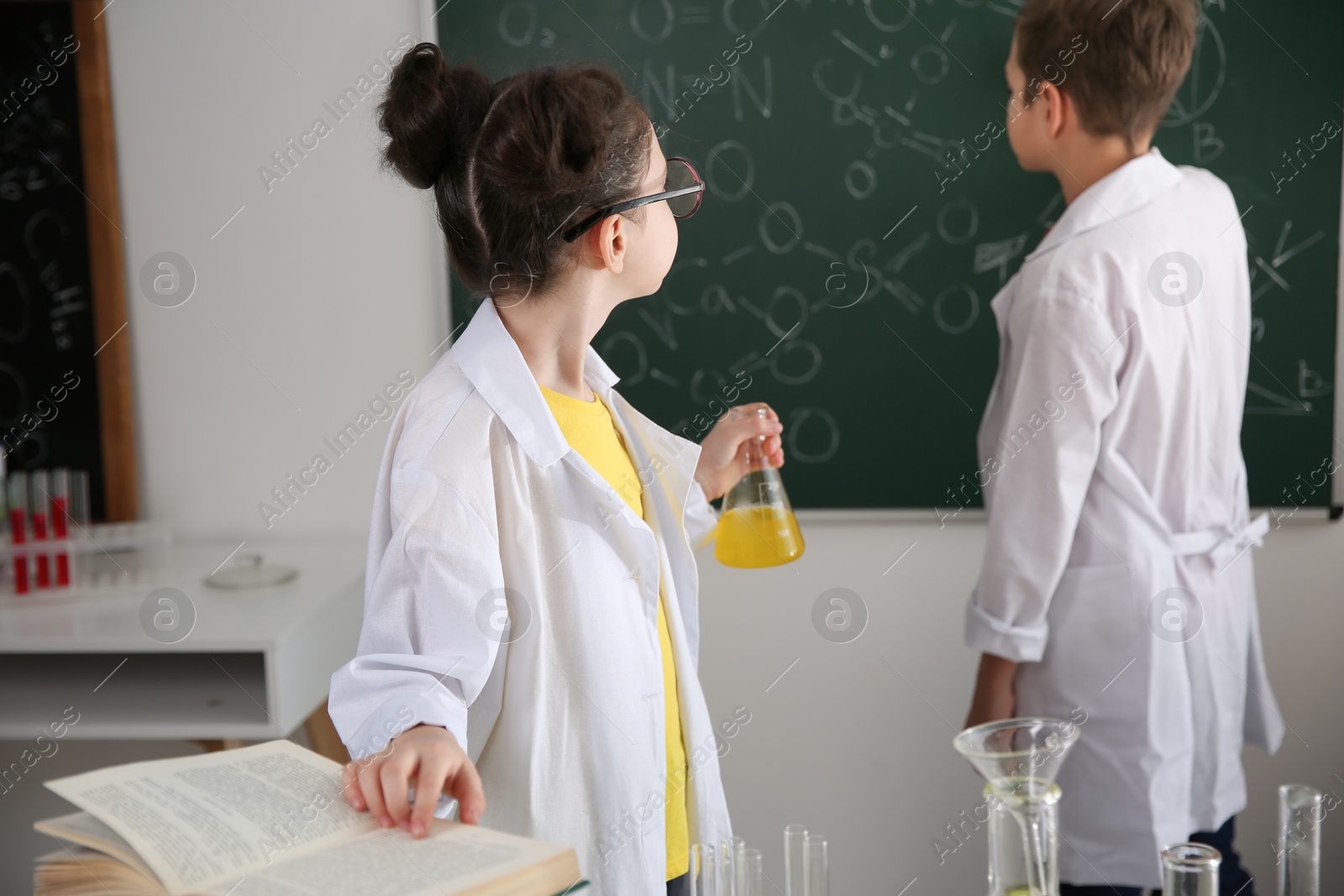 Photo of Smart pupils making experiment in chemistry class