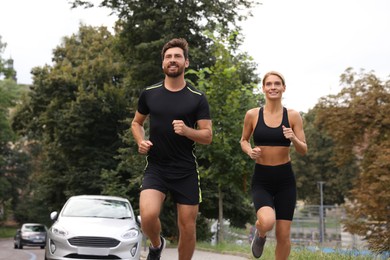 Photo of Healthy lifestyle. Happy sporty couple running outdoors