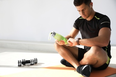 Man checking fitness tracker during training in gym