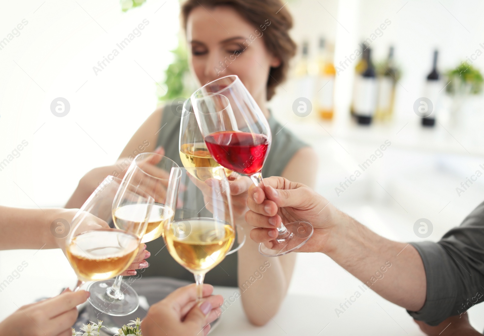 Photo of Young people with glasses of delicious wine at table