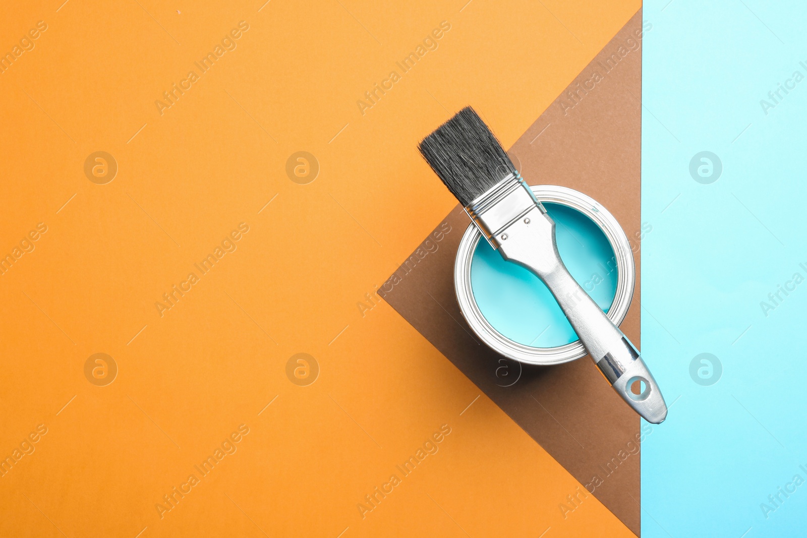 Photo of Paint can and brush on color background, top view. Space for text