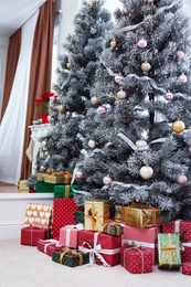 Many different gifts under Christmas tree indoors